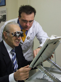 Il dottor Lino Trabuio mostra ad un paziente il corretto utilizzo di una lente per ipovisione